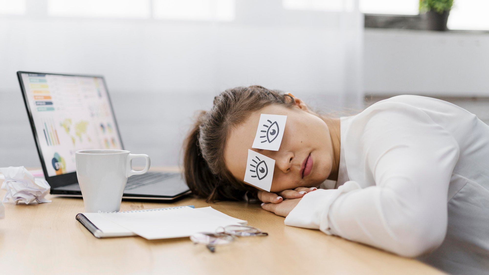 tired-businesswoman-covering-her-eyes-with-drawn-eyes-paper tired-businesswoman-covering-her-eyes-with-drawn-eyes-paper