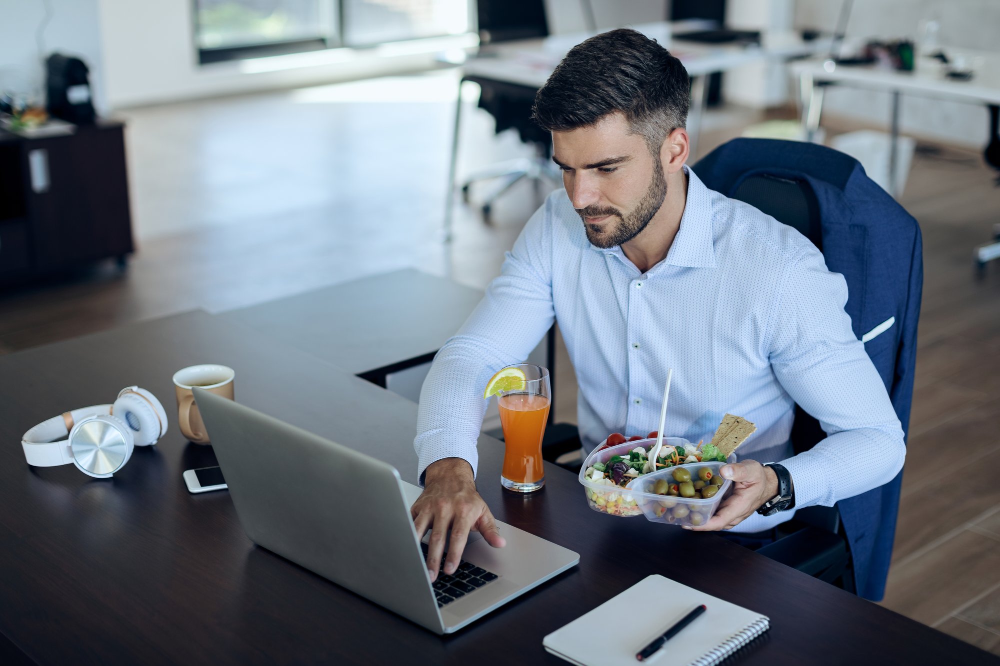 young-entrepreneur-working-laptop-while-having-lunch-break-office young-entrepreneur-working-laptop-while-having-lunch-break-office